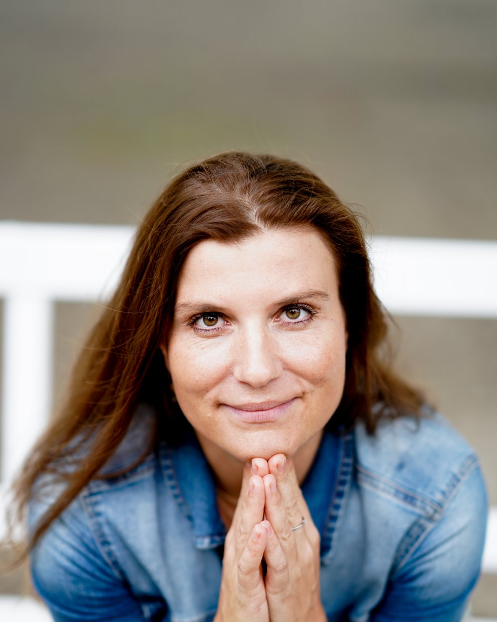 Yvonne Gessner lächelt mit gefalteten Händen in die Kamera